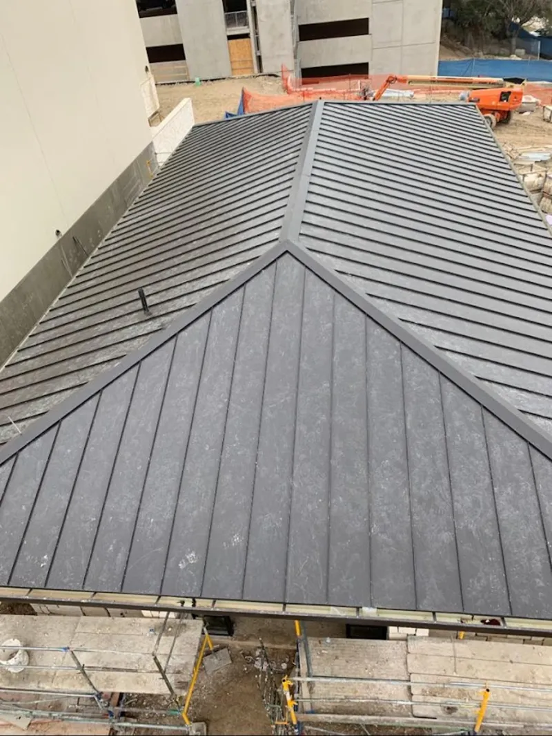 Commercial metal roof construction with crane equipment in Kahaluu